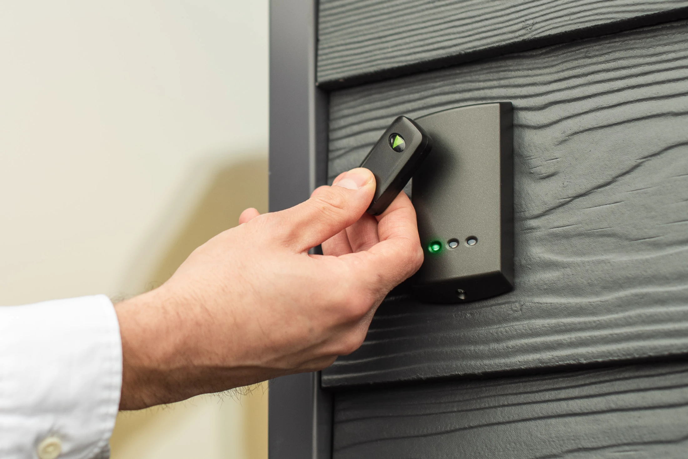 A Paxton access fob presented to a wall-mounted reader.